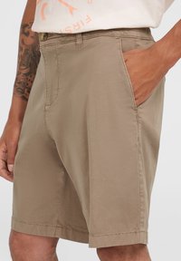 Beige Shorts mit geradem Schnitt, leichtem Stoff, Seitentaschen und Knopfverschluss. Verfügt über sichtbare Nähte und eine glatte Textur.