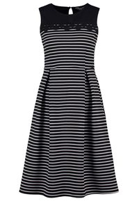 Ärmlös svart klänning med vita horisontella ränder, spetsdetalj vid övre delen av bröstet, figursydd midja och utsvängd kjol.