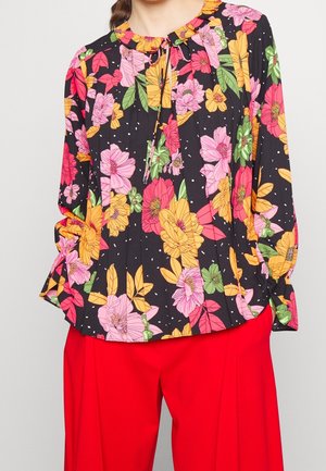 Bluse mit floralem Muster auf schwarzem Hintergrund, verziert mit rosa, gelben und grünen Blumen. Puffärmel und ein geraffter Ausschnitt mit einer Bindeschnur.