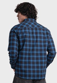 Langärmliges kariertes Hemd in Blau und Schwarz, mit klassischer Passform, Button-Down-Kragen und strukturiertem Stoff mit karriertem Muster.