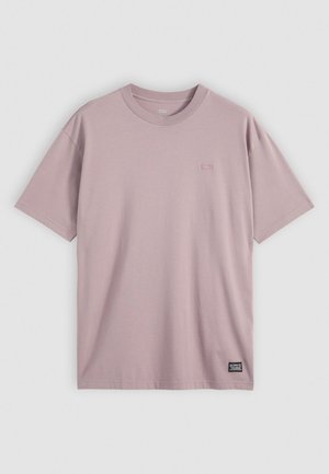 T-shirt en coton rose clair à manches courtes, col rond et petit logo brodé sur la poitrine. Texture douce, design décontracté.