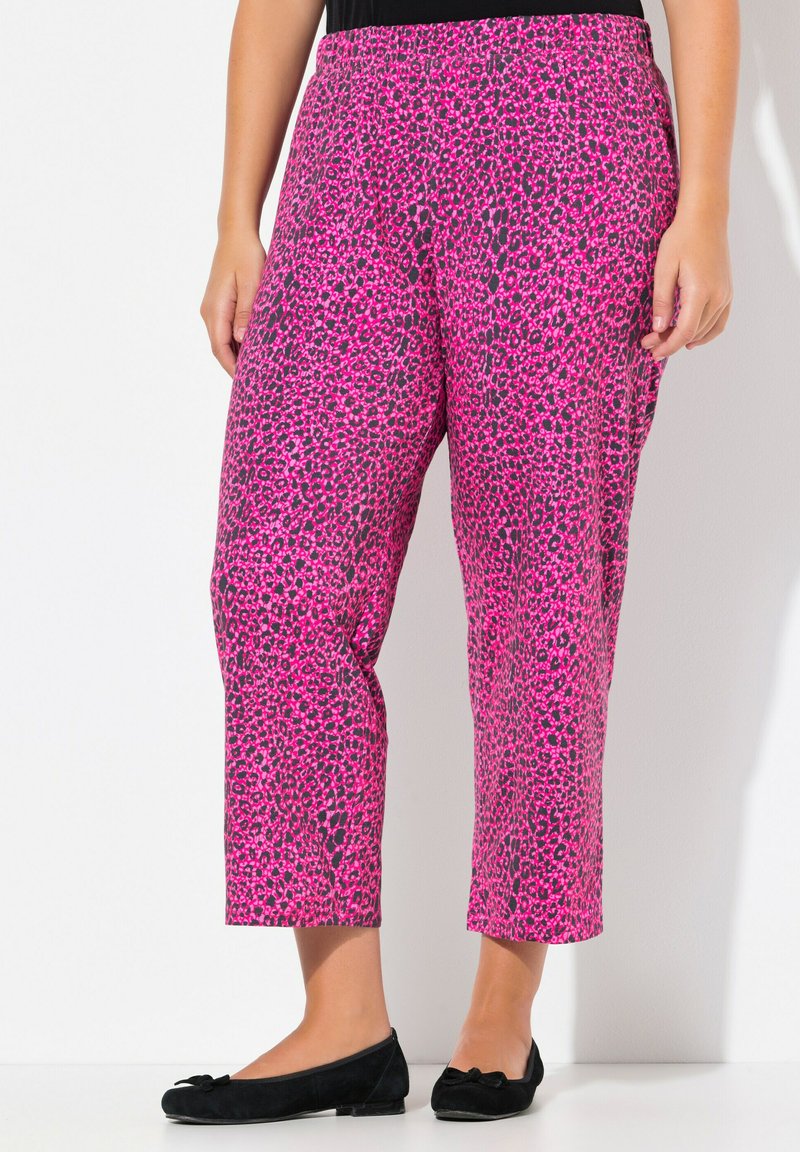Růžové kalhoty s leopardím potiskem, elastickým pasem, volným střihem a zkrácenou délkou, doplněné černými balerínami. Hladká tkanina s lesklou texturou.