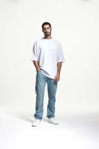 Witte oversized t-shirt, lichtblauwe spijkerbroek en witte sneakers. Eenvoudig, relaxte pasvorm met korte mouwen en een eenvoudige ontwerp.