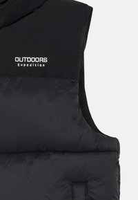 Crna prsluk od pufaste tkanine s visokim ovratnikom i logom "OUTDOORS Expedition" u bijeloj boji. Karakterizira ga glatka, sjajna tekstura i elegantan dizajn.