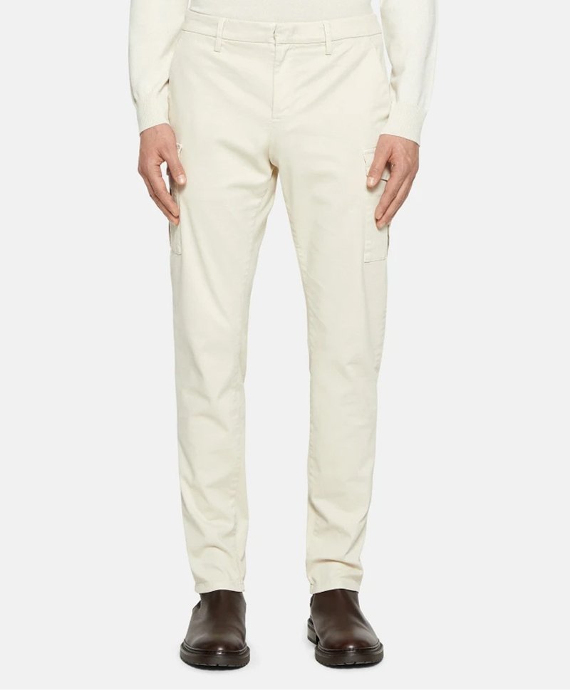 Pantaloni cargo beige con vestibilità dritta, dotati di due tasche laterali e una texture in cotone liscia. Abbinati a stivaletti alla caviglia marrone scuro.