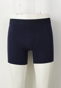 Tengerészkék boxer alsónadrág sima textúrával és fekete elasztikus derékpánttal, amelyen finoman bele van gravírozva a "BJÖRN" márkaneve.