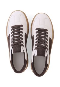 Baskets blanches avec des accents en suède brun, présentant un dessus texturé, un bout rond et des lacets plats. Semelle en caoutchouc avec un léger motif, design moderne.