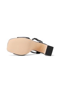 Sandalo nero con tacco quadrato, cinturino regolabile e tomaia in pelle liscia. Suola in gomma texturizzata per una buona aderenza, suola esterna color beige chiaro.