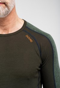 Langærmet termisk skjorte i mørkegrøn med kontrasterende teksturerede skulderpaneler. Har orange "DOVRE" logo og blå stikninger som accenter.