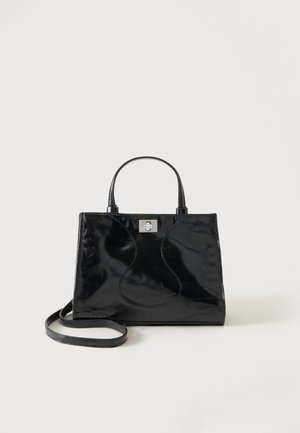 Sac à main en cuir verni noir avec poignées arrondies, bandoulière détachable et fermeture à boucle argentée sur fond blanc uni.