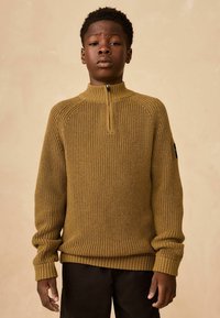 Senf-farbener Strickpullover mit hohem Kragen und kurzem Reißverschluss, mit gerippten Bündchen und Saum, strukturiertem Stoff und Raglansleeves.