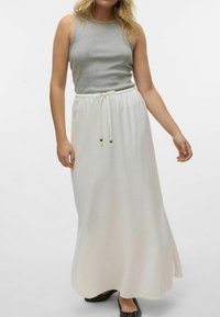 Haut gris sans manches associé à une longue jupe blanche avec une taille élastique, un cordon de serrage et deux accents en perles de bois.