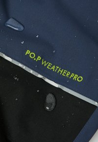 Merivesi kestävä kangas, jossa on vihreä "P.O.P WEATHERPRO" -tunnus; pinnalla vesipisaroita, mikä osoittaa sen vedenpitävyyttä.