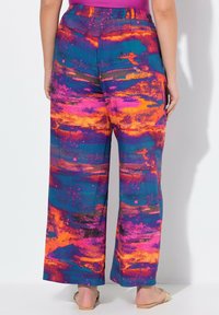 Brede benen broek met een levendig abstract patroon in roze, oranje en blauw. Elastische tailleband en lichtgewicht stof voor comfort.