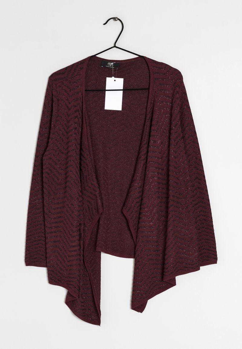 Kastanjefärgad öppna cardigan med långa ärmar och chevronmönster som hänger på en svart galge mot en vit bakgrund.