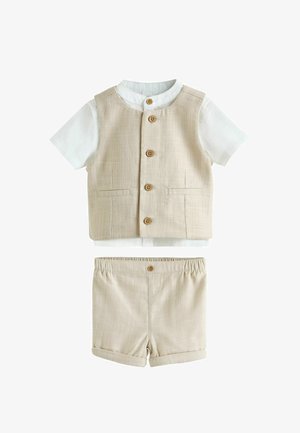 Beige linnedvest med træknapper, hvid kortærmet skjorte under, og matchende beige linnedshorts med knap og elastik i taljen.