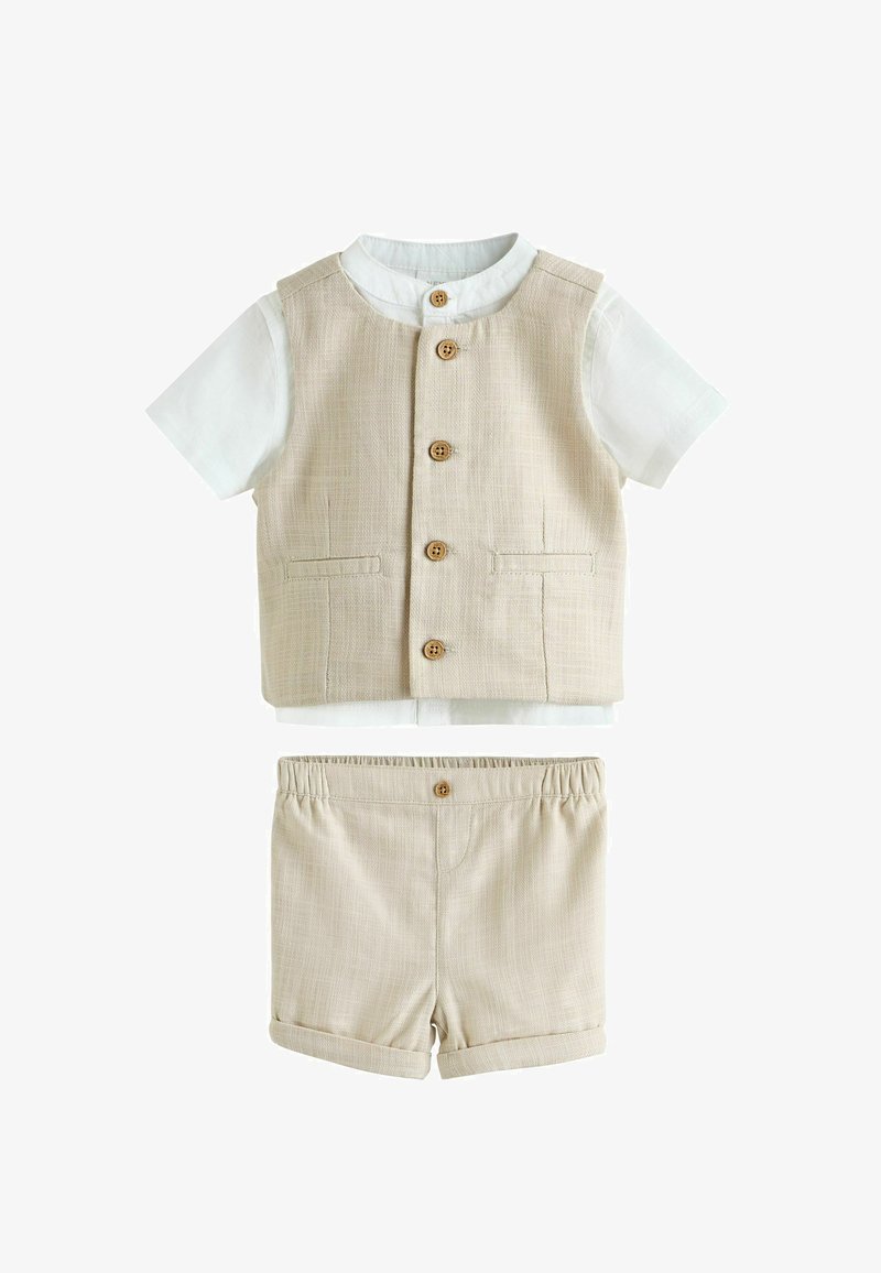 Gilet en lin beige avec boutons en bois, chemise blanche à manches courtes en dessous, et short en lin beige assorti avec bouton et taille élastique.