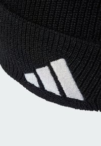 Black ribbed knit beanie featuring a white embroidered three-stripe logo detail, providing a textured appearance.