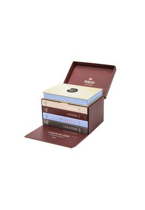 Coffret marron contenant quatre livres colorés empilés à l'intérieur. Titres : Partager, Donner, Célébrer, Créer. Le couvercle présente un logo et un design en spirale.