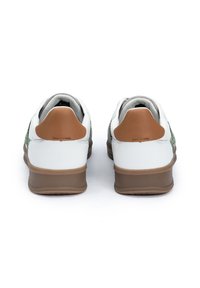 Zapatillas blancas con acentos verdes, tapas de talón marrón, suelas de goma y un acabado texturizado. Presentan lengüetas y partes traseras acolchadas para mayor comodidad.