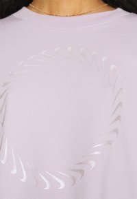 Fialová mikina s kulatým vzorem vyvýšených lesklých akcentů. Tkanina má měkkou texturu a kulatý výstřih.