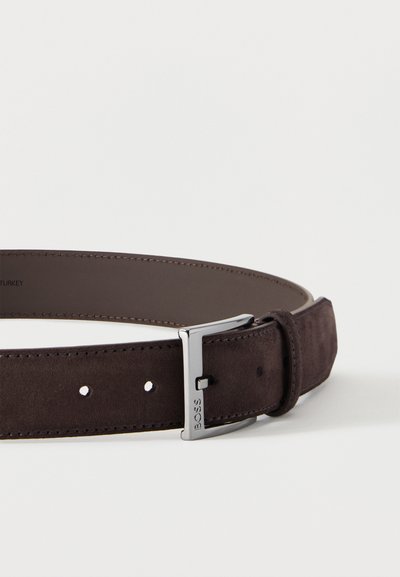 Ceinture en daim marron foncé avec une boucle en métal argenté gravée de "BOSS" et des bords cousus, posée à plat sur un fond blanc.
