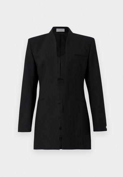 Melnā žakete ar izgriezumu, viena priekšējā kabata, gluda tekstūra un elegants dizains. Aprīkota ar garām piedurknēm un pielāgotu siluetu.