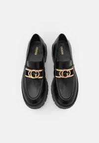 Black leather loafers featuring a gold-tone double G hardware accent, padded collar, and textured black rubber sole.