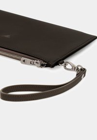 Clutch in pelle nera con superficie strutturata, dettagli in argento, chiusura con cerniera e cinturino da polso staccabile. Design lineare con accenti minimalisti.