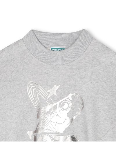 Sweatshirt en coton gris avec un imprimé graphique argenté représentant un poisson, des étoiles et des cercles. Le col à côtes ajoute de la texture au design.