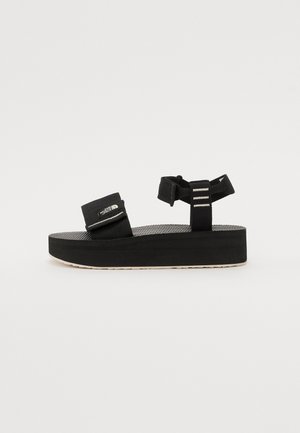 Black platform sandals featuring textured footbed, dual adjustable straps, and light-colored sole with accent stripes on the straps.