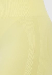 Geel leggings met een geribbelde textuur en een gladde afwerking, ontworpen met subtiele rondingen en lijnen voor een gestroomlijnde uitstraling.
