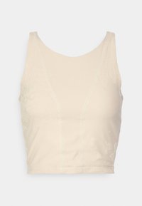 Crop top beige avec un col rond, présentant des motifs floraux texturés et des détails cousus, fabriqué à partir d'un tissu lisse.