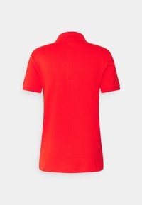 Rode katoenen polo met korte mouwen en een klassieke kraag. Gladde textuur, geen patronen of versieringen, toont een eenvoudige achteraanzicht.