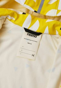 Geel en wit gestreepte stof met een label van "reima," wat wijst op duurzaam ontwerp. Zachte textuur, met zichtbare blauwe driehoekige vormen.