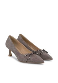 Zapatos de tacón alto de ante gris con punta afilada y tacón medio, que cuentan con una correa decorativa con cristales en la parte superior.