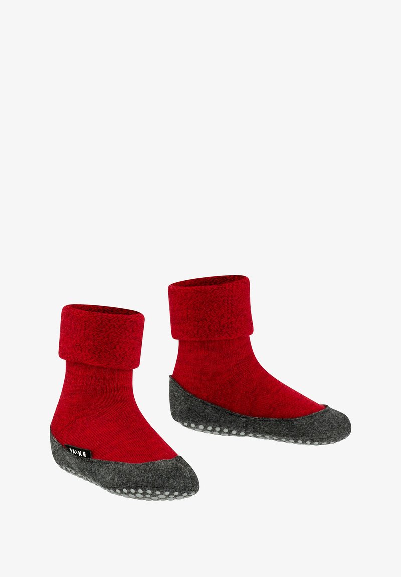 Rode gebreide slofjes met een omgeslagen boord, voorzien van een grijze vilten zool en witte antislipdoppen voor grip. Zachte stof voor comfort.