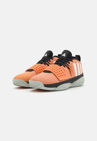 Oranje sportieve schoenen met zwarte accenten, bovenwerk van mesh, perforeerde details, rubberen zool en drie witte strepen aan de zijkant.