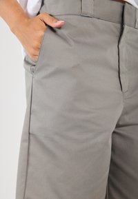 Gray cotton blend pants with a smooth texture, straight-cut design, and side pockets. Features a visible waistband and no patterns or hardware.
