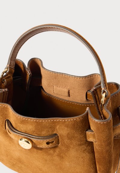 Brązowa zamszowa torba o zaokrąglonym dnie, z krótkim uchwytem i złotymi detalami. Wnętrze podszyte gładkim materiałem. Bez zapięcia, w otwartym stylu.