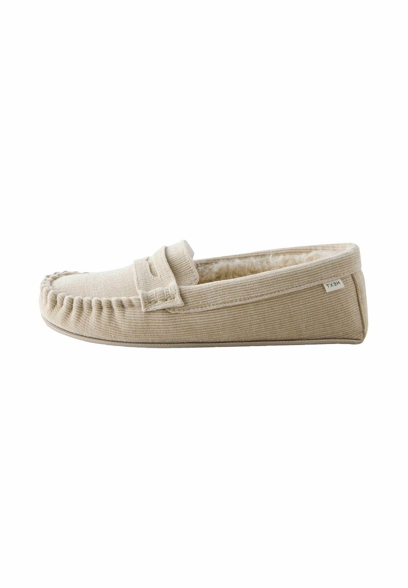 Beige moccasin pantoffel gemaakt van gestructureerde stof met een zachte binnenvoering. Heeft gestikte details en een verhoogde naad langs de tenen.