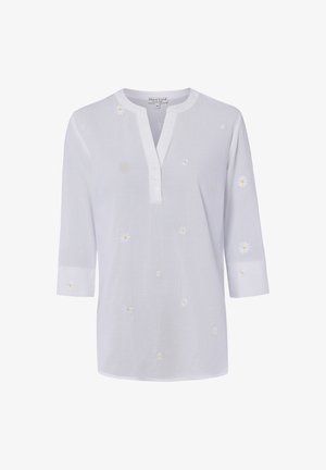 Witte blouse met lange mouwen met kleine witte en gele madeliefjes, drieknoopsbies en ronde halslijn.