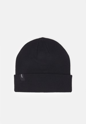 Schwarze Strickmütze mit umgeschlagenem Bündchen und kleinem Stoffetikett an der Seite, flach auf weißem Hintergrund gelegt.
