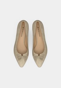 Chaussures plates beiges en daim à bout pointu avec des nœuds décoratifs sur le dessus, étiquetées "PETER KAISER" à l'intérieur.