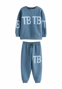 Twee-delige sweatsuit in lichtblauw. Trui heeft een groot "TB" logo, ronde hals en ribgebreide manchetten. Broek heeft een elastische tailleband en taps toelopende benen.