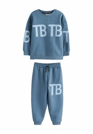Twee-delige sweatsuit in lichtblauw. Trui heeft een groot "TB" logo, ronde hals en ribgebreide manchetten. Broek heeft een elastische tailleband en taps toelopende benen.
