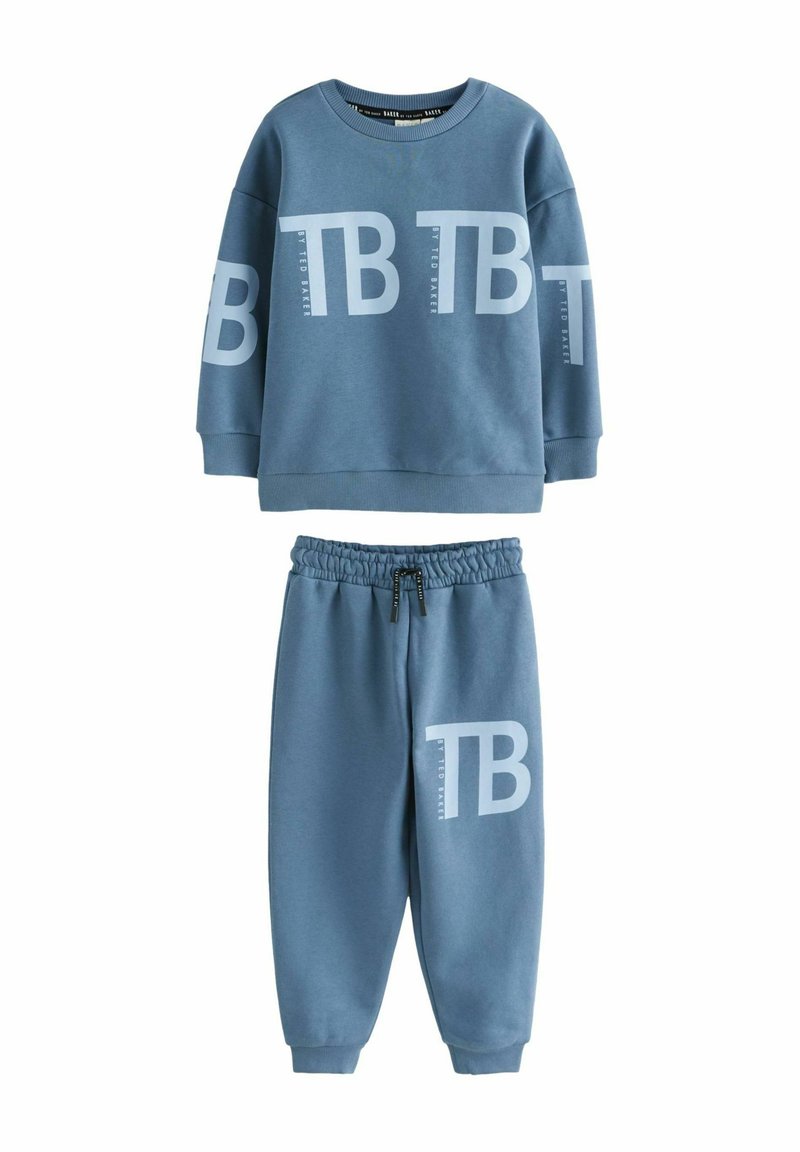 Twee-delige sweatsuit in lichtblauw. Trui heeft een groot "TB" logo, ronde hals en ribgebreide manchetten. Broek heeft een elastische tailleband en taps toelopende benen.