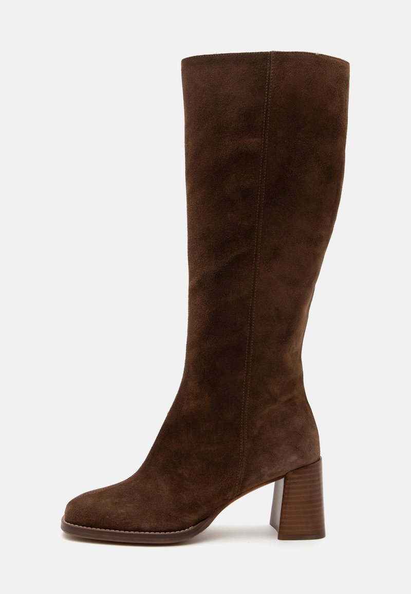 Καφέ καστόρινη μπότα μέχρι το γόνατο με στρογγυλή μύτη και στοιβαζόμενο τετράγωνο τακούνι, πλευρική όψη σε απλό φωτεινό φόντο.