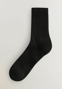 Schwarze Crew-Socke mit gerippter Textur, hergestellt aus einem weichen Stoff, mit verstärkten Zehen- und Fersenbereichen für Haltbarkeit.