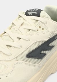 Sneaker featuring a creamy white mesh and suede upper, with grey accents and laces; textured rubber sole; logo on the tongue.